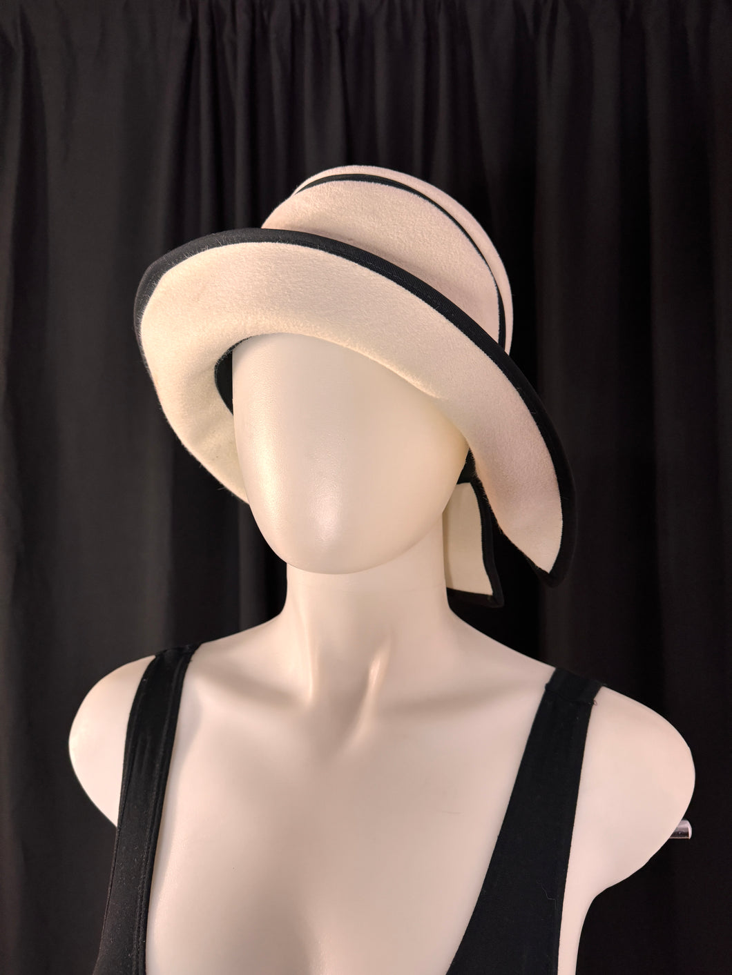 3/4 view of black and white cloche hat designed by Mr John Jr, a celebrated hat designer of post war 1960s.