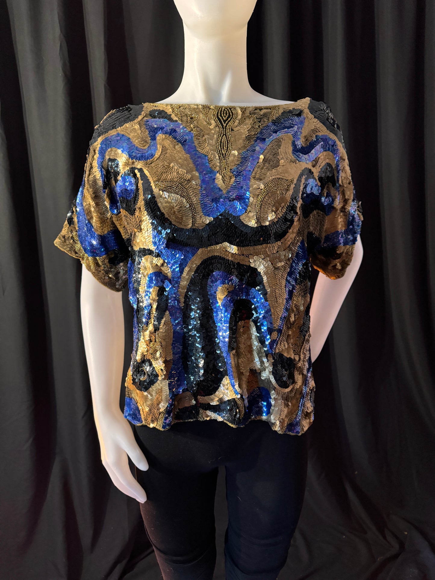 Oleg Cassini top on mannequin, front view. The length is 21 inches. The width is 21 inches. Sleeve opening is 14 inches round and extends 12 inches from neckline.