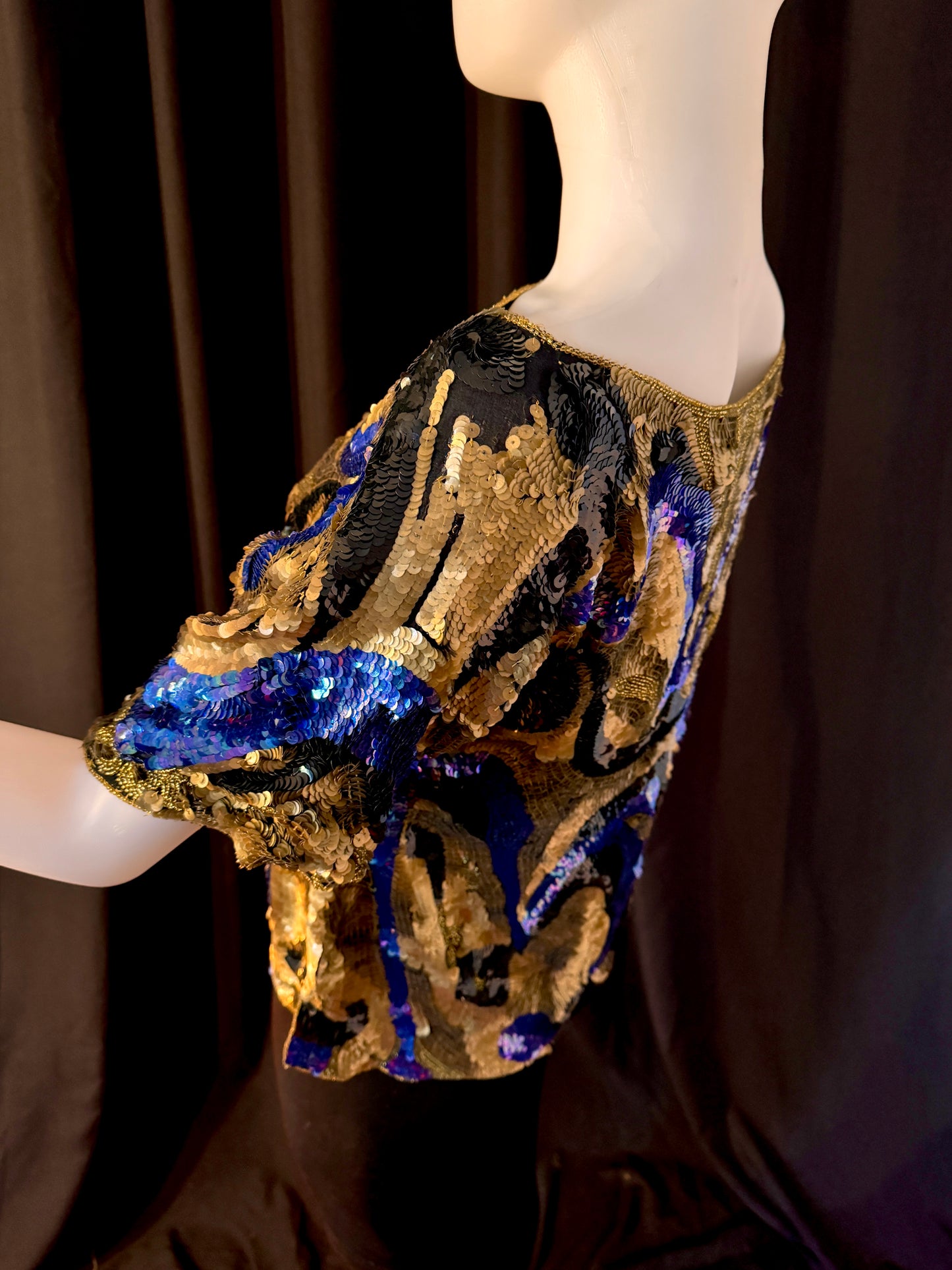 Side view of mannequin from above: Oleg Cassini Sequined top, Size M. There is a small patch on each shoulder missing sequins but it looks as if it is part of the design. 