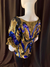 Load image into Gallery viewer, Oleg Cassini sequined top, back view on Mannequin with emphasis on blue and black swirling pattern against gold background. 
