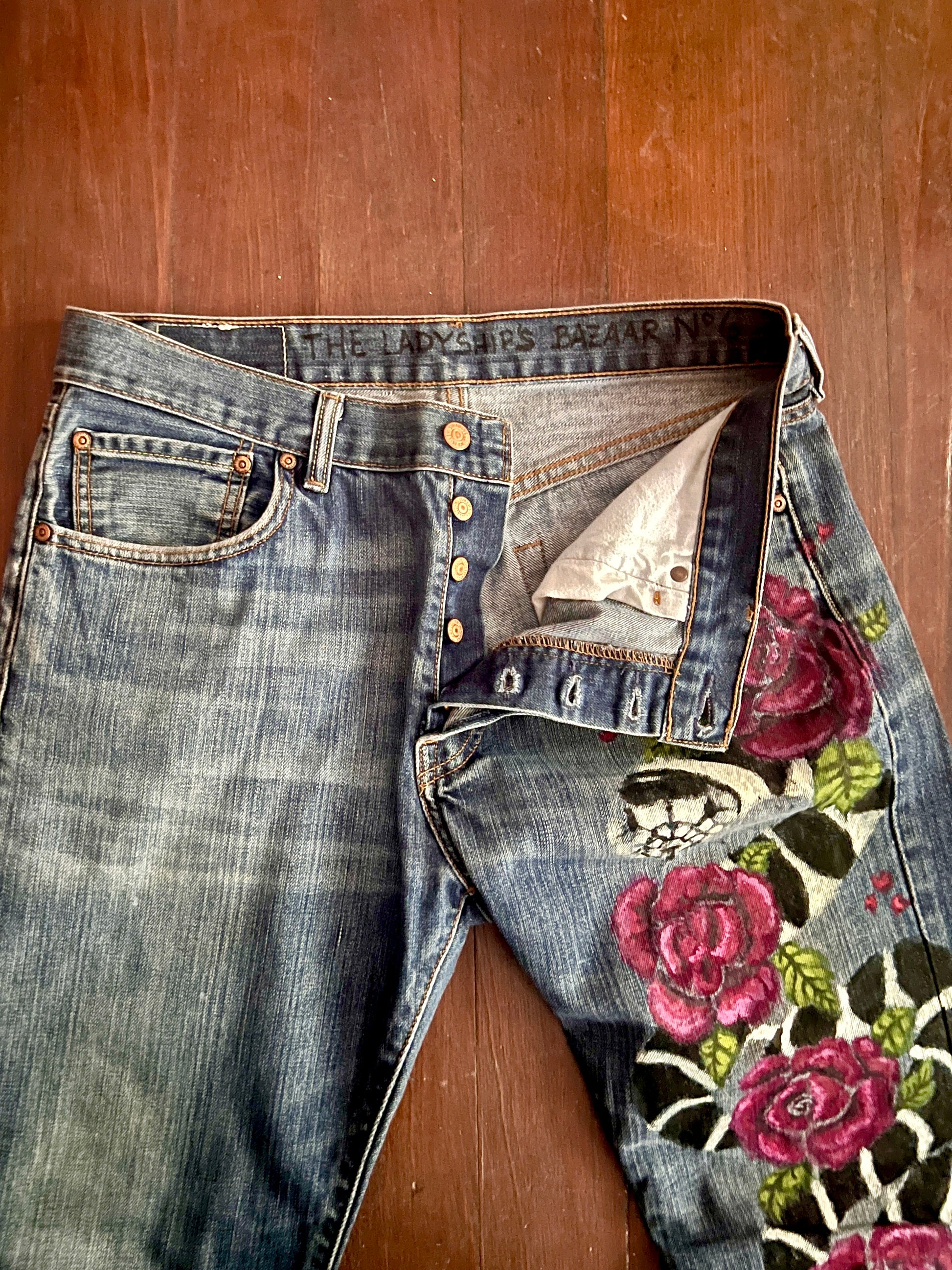 Front view, close up of butterfly opening of Levi's 501 jeans and the head of King Snake