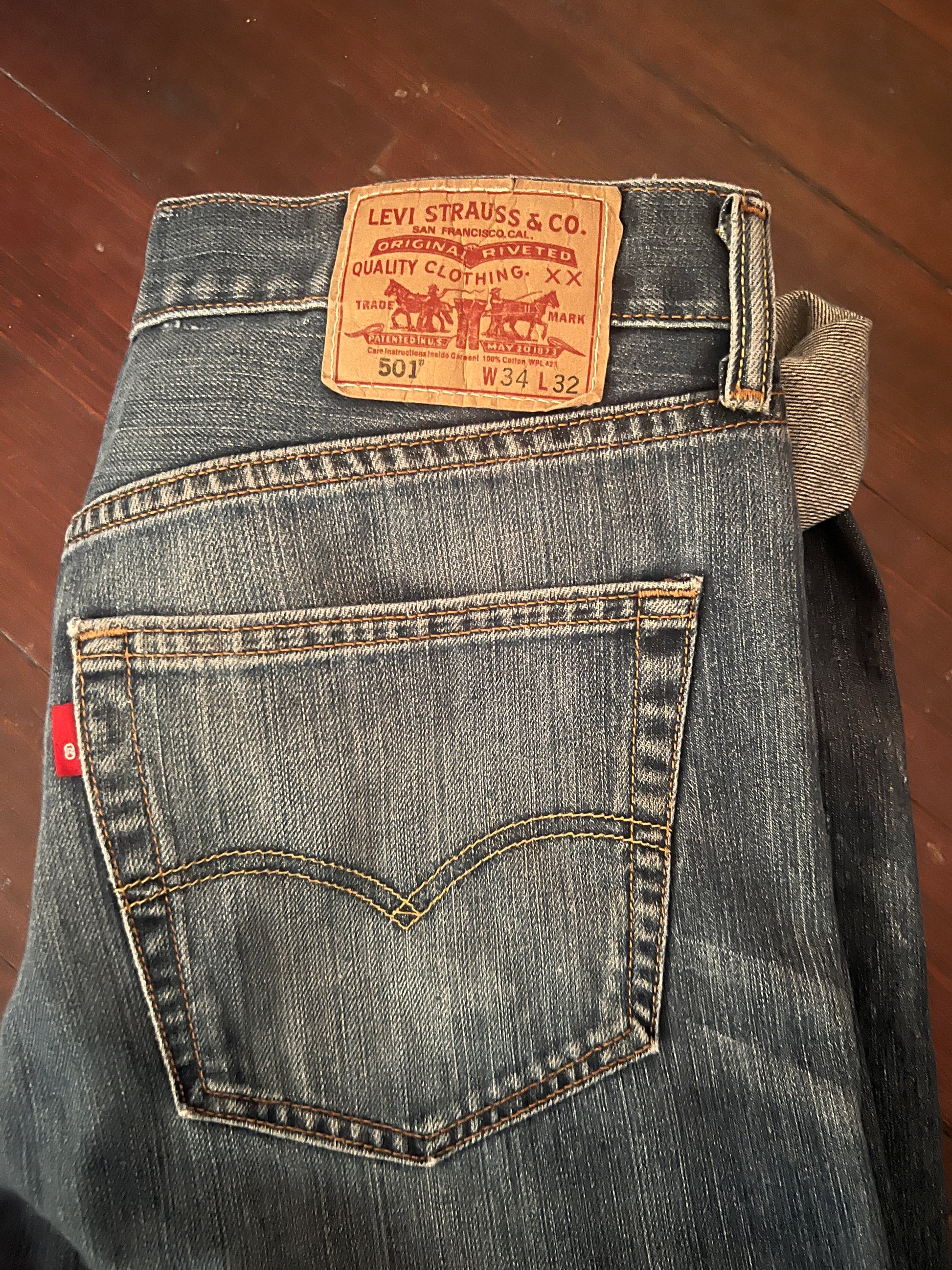 View of back pocket and Levi's 501 label. The jeans are pre-owned in good condition with distress hems.