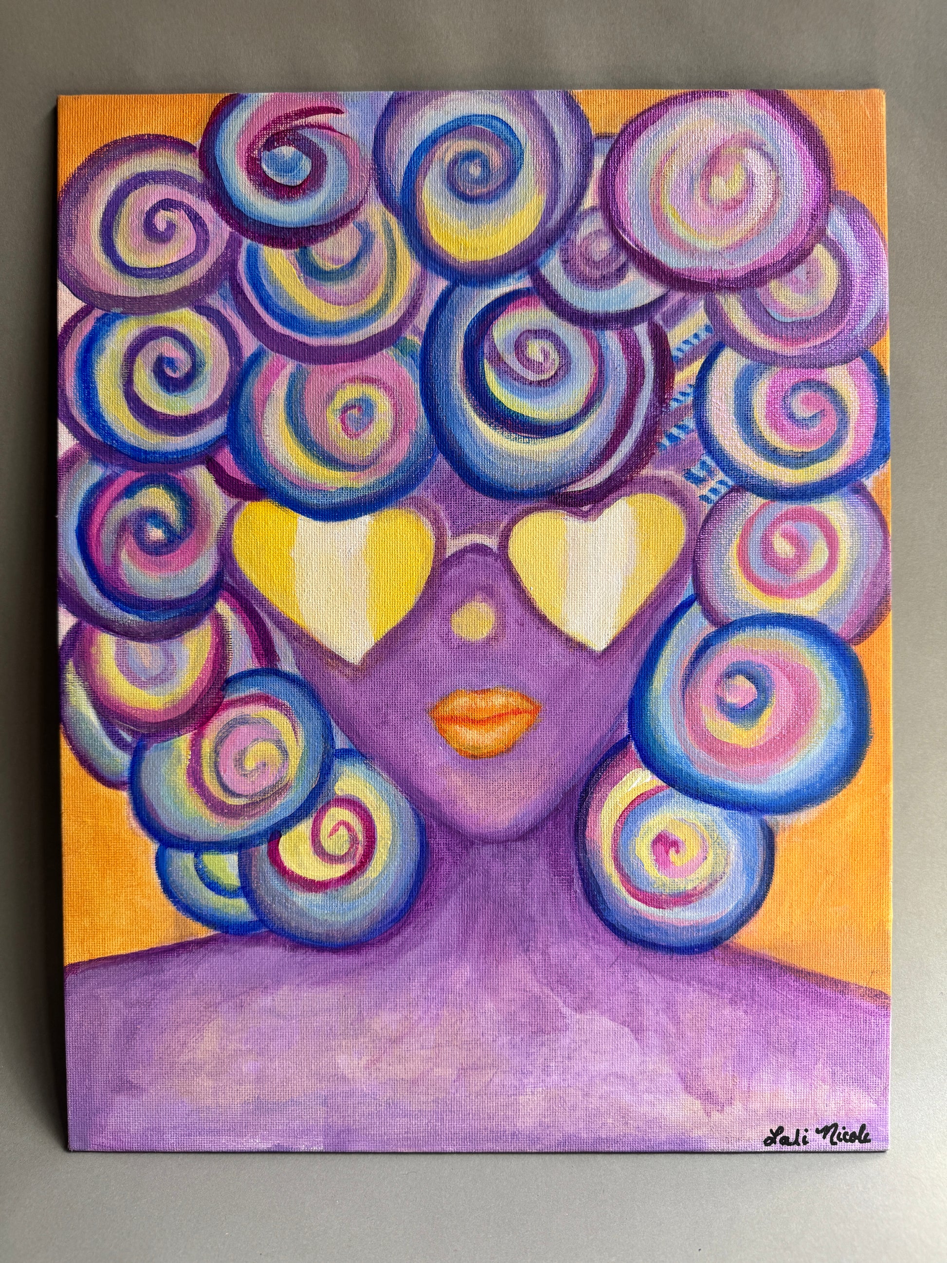 The original colorful painted portrait artwork of a stylized face with swirling hair-like forms in purple, blue, pink, and yellow with orange background, photographed against a neutral gray wall. The oriinal is painted on 11x14 canvas board